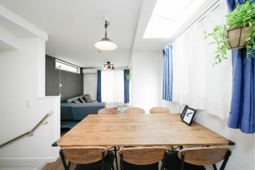 ein Esszimmer mit einem Holztisch und Stühlen in der Unterkunft Higashi Rokugou WHITE / Vacation STAY 4276 in Tokio