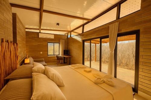 a bedroom with a large bed with a large window at Sertão do Luar in Jurubeba