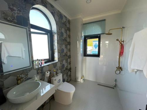a bathroom with a sink and a toilet and a tub at The Vista My Hoa in Ninh Hải