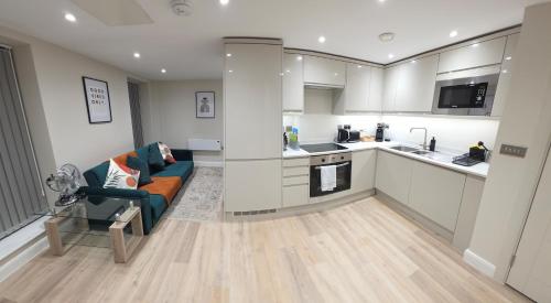 a living room with a couch and a kitchen at Cosy Leeds City Centre Apartment in Central Station