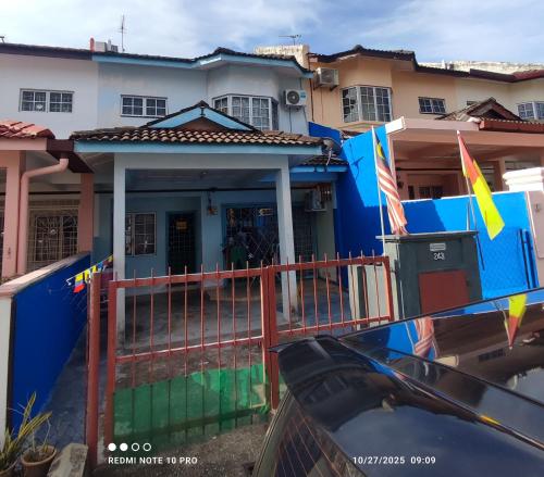 スレンバンにあるHomestay Dasuqiの塀と旗を前に建つ家
