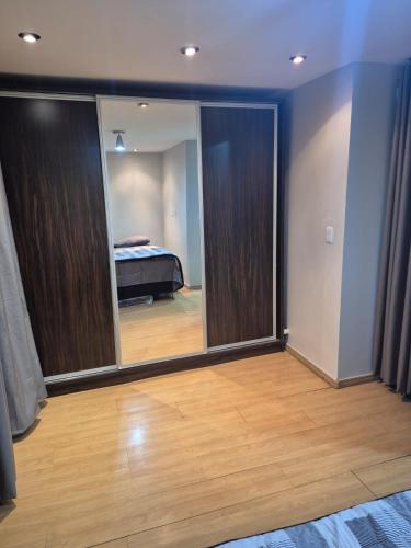 a room with a mirror and a bedroom with a bed at Um lar em Brasília, super aconchegante e com ar condicionado in Brasília