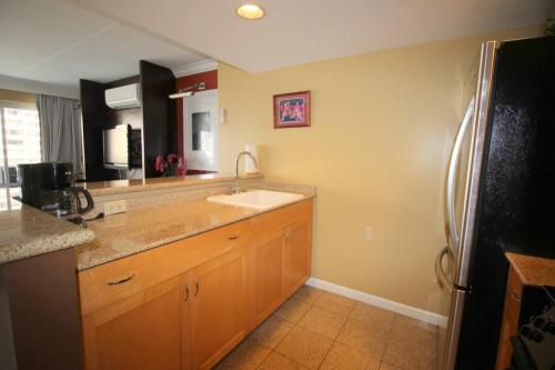 eine Küche mit Spüle und Kühlschrank in der Unterkunft Waikiki - Resort amenities, walk to the beach! in Honolulu