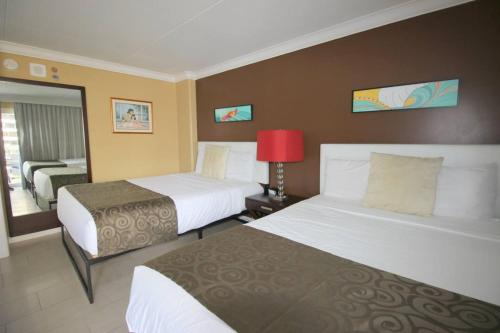ein Hotelzimmer mit 2 Betten und einer roten Lampe in der Unterkunft Waikiki - Resort amenities, walk to the beach! in Honolulu