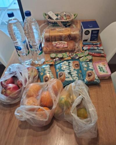 Una mesa con bolsas de comida y botellas de agua. en Valmere Apartment Tivat Sea View Free Parking, en Tivat