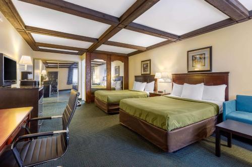 a hotel room with two beds and a table and chairs at Quality Inn in Lomita