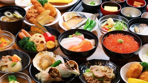 a table topped with bowls of different types of food at Dormy Inn Premium Otaru in Otaru