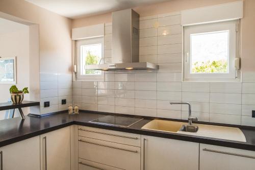 a kitchen with a sink and two windows at Villa Diosa de la Aurora in Klis