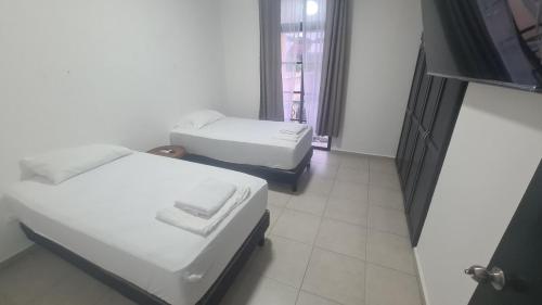 une chambre avec deux lits et une fenêtre dans l'établissement Casa Pochó frente al Hospital Ángeles, à Villahermosa