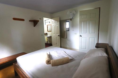 - une chambre avec un lit blanc et une serviette dans l'établissement Hostel Life is Good, à Moyogalpa