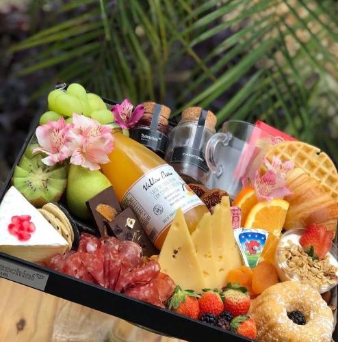 ein Tablett mit Käse, Obst und anderen Speisen in der Unterkunft Morphée Lodge in Saint-François