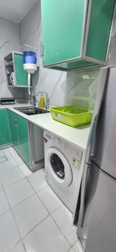 una cocina con lavadora y fregadero en Sky chalet, en Sur