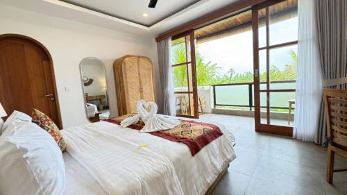 a bedroom with a large bed and a balcony at Candra Villa Kedungu in Tanah Lot