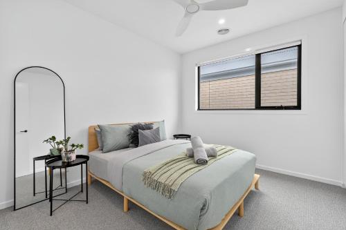 Una cama o camas en una habitación de Duneview Luxe Ocean Grove Sleeps 8, 4 bedroom, aircon,heating throughout, Designer quality, Perfect wedding stay, family friendly, Beach, Park, Shops