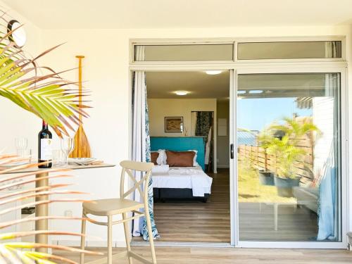 a bedroom with a bed and a sliding glass door at Air-conditioned sea access studio, fiber optic, parking in Punaauia