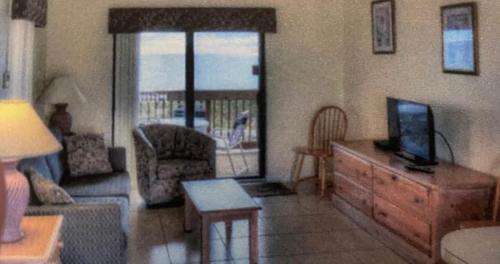 a living room with a couch and a tv on a dresser at Beachfront Aparthotel in Deerfield Beach with Panoramic Views of the Ocean! in Deerfield Beach