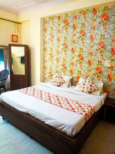 ein Schlafzimmer mit einem großen Bett mit geblümter Tapete in der Unterkunft Hotel Surya Mahal in Jaipur