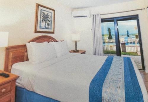a bedroom with a bed with a view of the ocean at Beachfront Aparthotel in Deerfield Beach with Panoramic Views of the Ocean! in Deerfield Beach