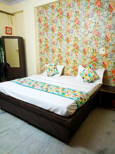 Bett in einem Schlafzimmer mit Blumentapete in der Unterkunft Hotel Surya Mahal in Jaipur