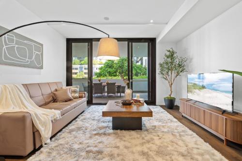 a living room with a couch and a large aquarium at Prestige 3BR Retreat with 2 Parking Prime Sydney in Sydney
