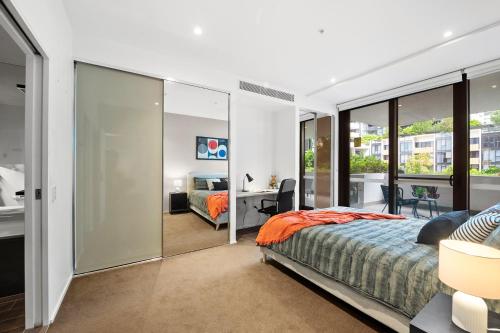 a bedroom with a king sized bed and a desk at Prestige 3BR Retreat with 2 Parking Prime Sydney in Sydney