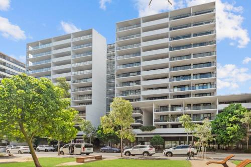 an apartment building with cars parked in front of it at Prestige 3BR Retreat with 2 Parking Prime Sydney in Sydney
