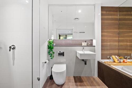 a bathroom with a toilet and a sink at Prestige 3BR Retreat with 2 Parking Prime Sydney in Sydney