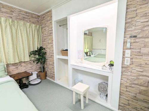 ein Schlafzimmer mit einem Spiegel an einer Backsteinwand in der Unterkunft Lavilla aveneu / Vacation STAY 73439 in Okinawa