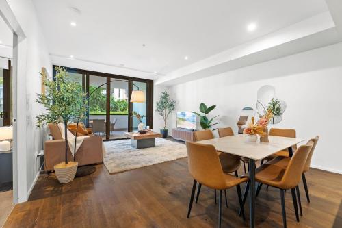 a dining room and living room with a table and chairs at Prestige 3BR Retreat with 2 Parking Prime Sydney in Sydney