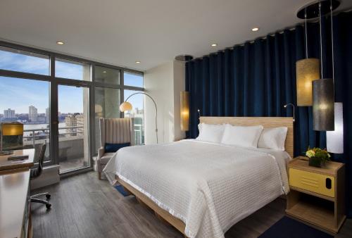 a bedroom with a large bed and a large window at Arthouse Hotel in New York