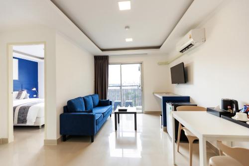 a hotel room with a bed and a blue chair at UTD8 Hotel and Residence in Bangkok