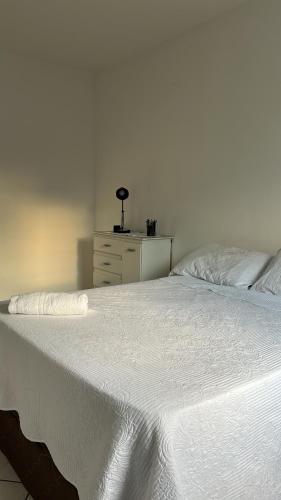 a white bed with a dresser in a bedroom at Quarto Moderno e aconchegante em Apartamento!!! in Foz do Iguaçu