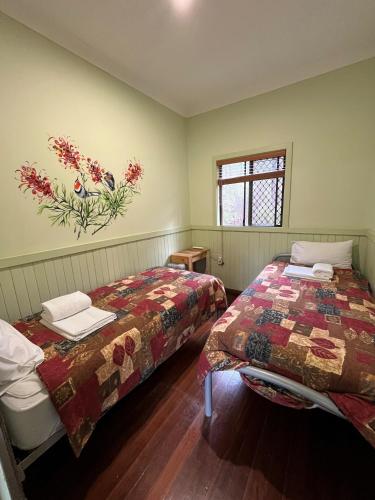a bedroom with two beds and a painting on the wall at Jarrah Forest Lodge in Dwellingup