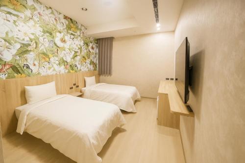 a hotel room with two beds and a painting on the wall at 星雨行館 Hotel in Mao-i-san-ts'un