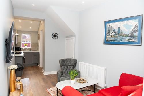 a living room with a red couch and a table at Rb Lodge Stockport in Stockport
