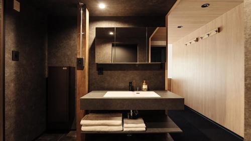 ein Badezimmer mit Waschbecken und Ablagefläche mit Handtüchern in der Unterkunft 瀾山ホテル LanshanHotel 澜山酒店 in Horonai
