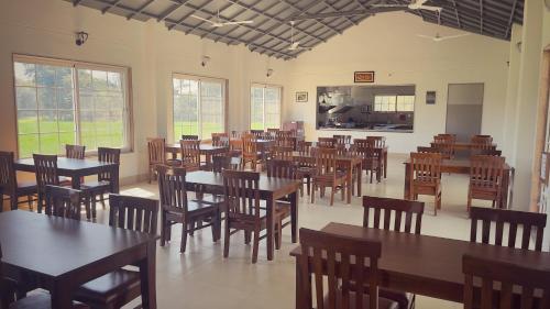 a dining room filled with tables and wooden chairs at Zen-stays in Bhopal