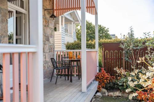 a porch with a table and chairs on a deck at Miss Midgley's - Refectory in Brisbane