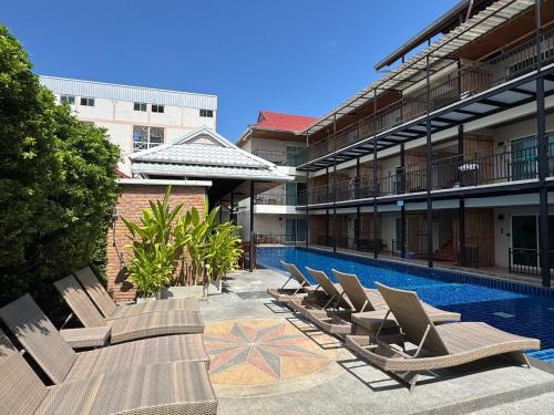 a row of lounge chairs next to a swimming pool at Celosia Chiang Mai Hotel in Chiang Mai