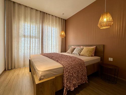 een slaapkamer met een bed en een raam bij The Urban Origami S703 in Long Bình