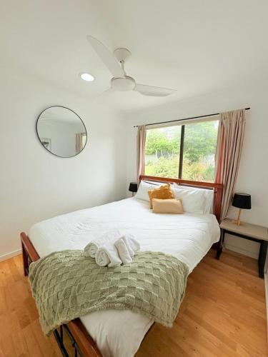 a bedroom with a large bed with towels on it at Sea-Renity at Treetops Family & Pet-Friendly Coastal Escape in Mollymook in Mollymook