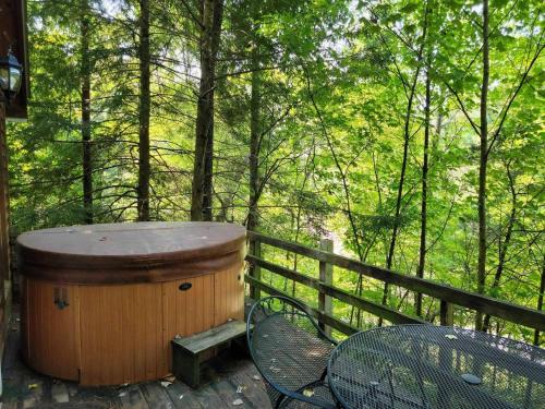 een houten hot tub op een terras met een tafel en stoelen bij Hot Tub & WiFi - Hidden Chalet Red River Gorge KY in Campton