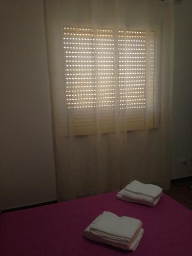 Lido SignorinoにあるVilla del Soleの窓付きのベッドに折りたたみ式タオル2枚が備わる客室です。