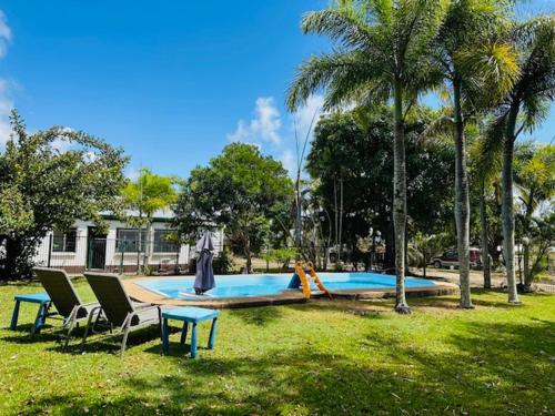 a swimming pool with two chairs and a slide at River of Gold Motel in Cooktown