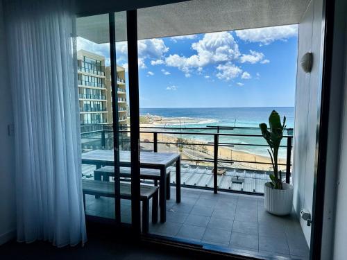a balcony with a table and a view of the beach at Nalu in Newcastle