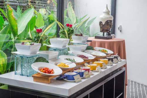ein Buffet mit Schüsseln voller Essen auf einem Tisch in der Unterkunft Khmer Lodge - Eco-Lodge in Phumĭ Réach Born