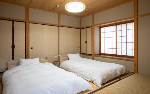 那须町rinne 2nd living Nasu Garden 2的有两张床的房间有两扇窗户