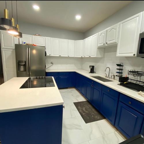 een keuken met blauwe kasten en een roestvrijstalen koelkast bij Private bathroom inside Master bedroom! in Paterson