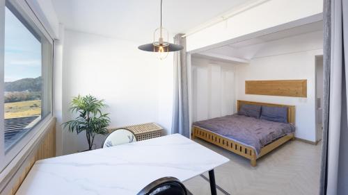 a bedroom with a bed and a large window at Namhae JJhouse Pension in Namhae