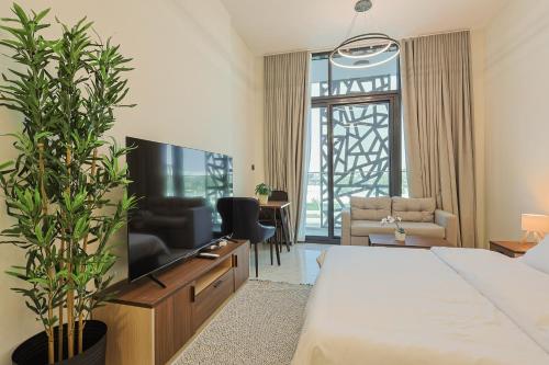 a hotel room with a bed and a tv at Masdar Modern Studio in Abu Dhabi